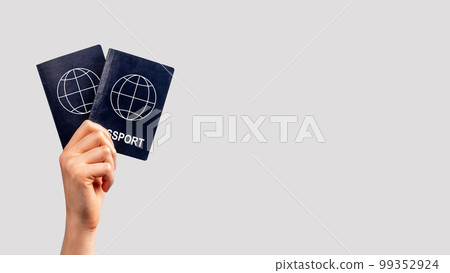 Banner with woman hand holding two passports. Family vacation, travel together concept. Identity, nationality verification. Copy space on grey background 99352924