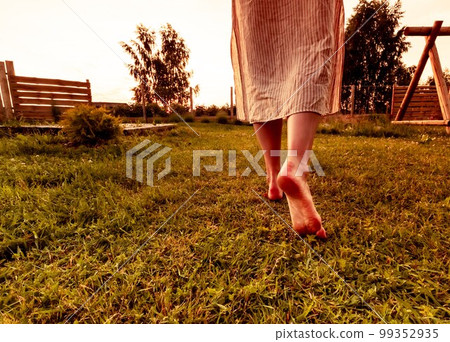 Barefoot woman walking on grass. Silence, privacy with nature, life enjoyment, freedom concept. Barefoot woman walking on grass. Silence, privacy with nature, life enjoyment, freedom concept. 99352935