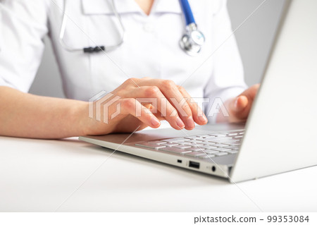 Doctor with stethoscope working on laptop, typing information about patient diagnosis, recommendations. Health care and medicine concept. Woman in lab coat sitting at desk with computer. 99353084