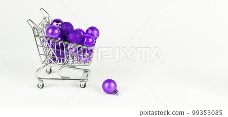 Banner with violet Christmas baubles in supermarket trolley. Shopping and preparing for holidays. Copy space Banner with violet Christmas baubles in supermarket trolley. Shopping and preparing for holidays. Copy space 99353085