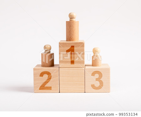Winners podium from wooden blocks with knobbed cylinders and numbers 1, 2, 3. Hierarchy, ranking concept. Distribution of places among competition champions 99353134