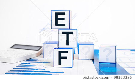 Investing in exchange traded funds. Cubes with ETF abbreviation, calculator and graphs. Financial concept. Making investments in stocks, bonds and commodities Investing in exchange traded funds. Cubes with ETF abbreviation, calculator and graphs. Financial concept. Making investments in stocks, bonds and commodities 99353386