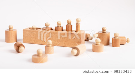 Block with incorrectly placed Montessori knobbed cylinders. Error in puzzle assembly. Disorder, confusion concept. Kids toy for development of dimension perception 99353433