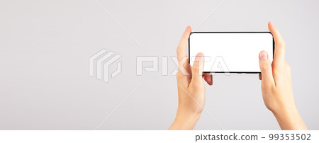 Banner with hands holding phone mockup in horizontal position. Woman using smartphone for playing games. Mobile gaming. template with blank display. Copy space Banner with hands holding phone mockup in horizontal position. Woman using smartphone for playing games. Mobile gaming. template with blank display. Copy space 99353502