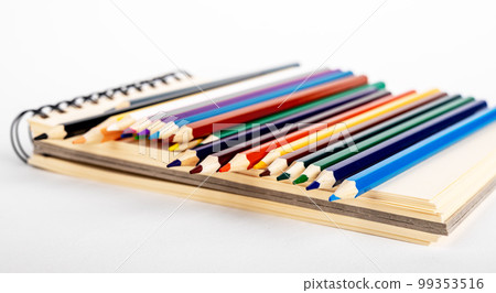 Colored pencils and sketchbook for creative art, drawing 99353516