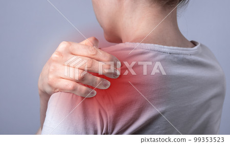 Woman suffering from shoulder pain. Hand holding painful shoulder with red point closeup. Joint injuries. Health care, medicine concept 99353523