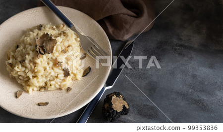Risotto with porcini mushrooms and black truffles served in a plate top view, gourmet cousine 99353836
