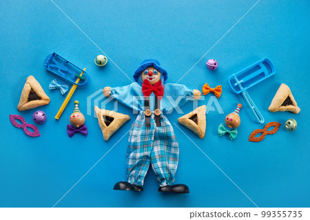 Purim celebration concept. Jewish carnival background. hamantaschen or hamans ears cookies, carnival mask and noisemaker Purim celebration concept. Jewish carnival background. hamantaschen or hamans ears cookies, carnival mask and noisemaker 99355735