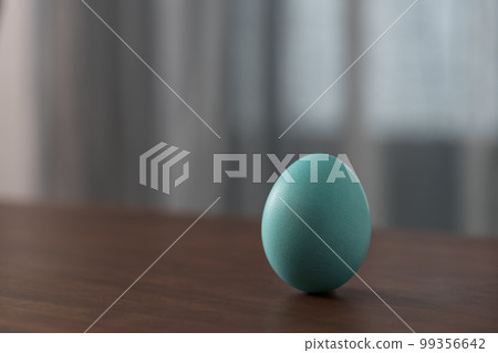 Azure Easter egg on a wooden table with copy space 99356642
