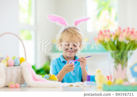 Kids on Easter egg hunt. Children dye eggs. 99356721