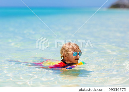 Kids surf on tropical beach. Vacation with child. Kids surf on tropical beach. Vacation with child. 99356775