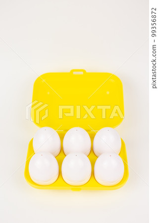 toy plastic eggs in a yellow case on a white background toy plastic eggs in a yellow case on a white background 99356872
