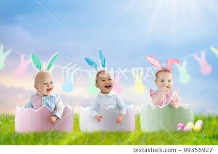 Baby with bunny ears on garden Easter egg hunt Baby with bunny ears on garden Easter egg hunt 99356927