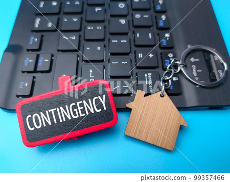 Keyboard and wooden house keychain with the word CONTINGENCY. 99357466