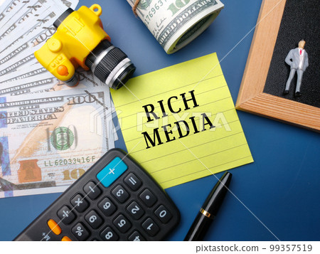 Camera and miniature people with text RICH MEDIA on a blue background.. Camera and miniature people with text RICH MEDIA on a blue background.. 99357519