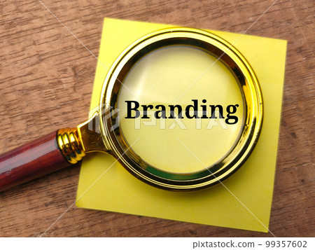 Vintage magnifying glass and sticky note with the word Branding. Business concept. 99357602