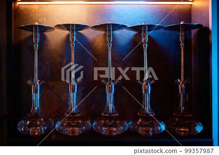 Row of hookahs with glass bulbs on display at market for sale Row of hookahs with glass bulbs on display at market for sale 99357987