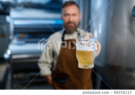 Freshly made craft beer in brewery worker hand, selective focus 99358113