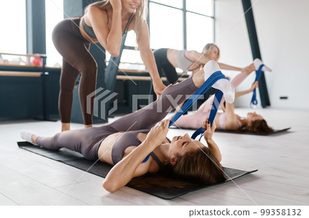 Group training for women, leg stretching with resistance fitness band Group training for women, leg stretching with resistance fitness band 99358132