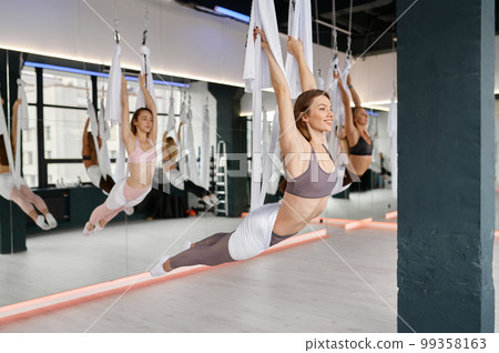 Fly yoga concept. Female group hanging on hammocks 99358163