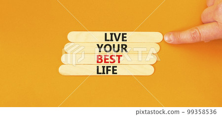 Live your best life symbol. Concept words Live your best life on wooden stick. Beautiful orange table orange background. Businessman hand. Business live your best life concept. Copy space. 99358536
