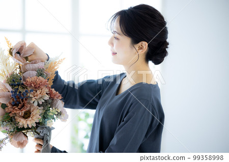 拿著花束的一件灰色禮服的婦女 99358998