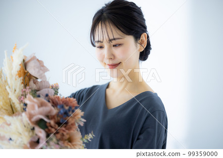 A woman in a gray dress holding a bouquet 99359000