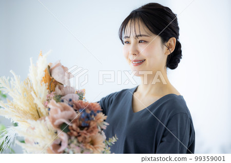 A woman in a gray dress holding a bouquet 99359001