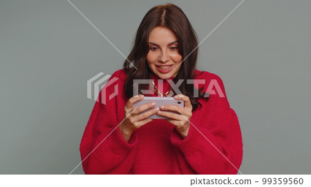 Worried funny addicted tourist girl enthusiastically playing drive racing video game on mobile phone 99359560