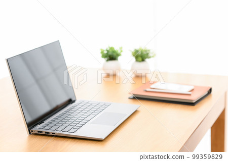 A laptop, system notebook, and smartphone on an indoor table 99359829