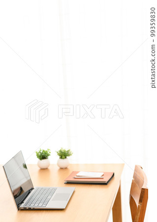 A laptop, system notebook, and smartphone on an indoor table 99359830
