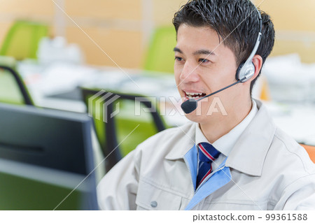 A man wearing work clothes working in a call center 99361588