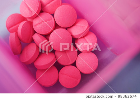 close up of pink color medical pills in a pill box on table close up of pink color medical pills in a pill box on table 99362674