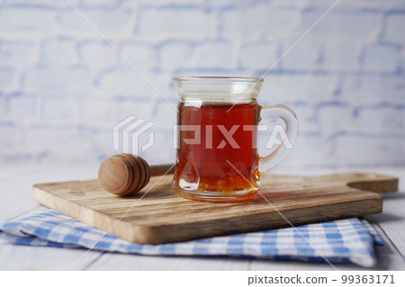 fresh honey in a jar and wooden spoon on table  99363171