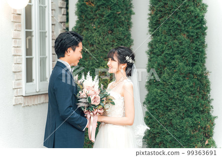 Bride and groom with a bouquet in the garden of the wedding hall at the wedding ceremony (garden wedding) 99363691