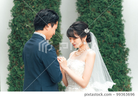 Bride and groom with a bouquet in the garden of the wedding hall at the wedding ceremony (garden wedding) 99363696