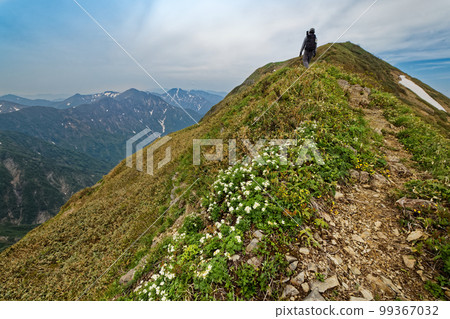 Climbers walking along the Tanigawa mountain range traverse and the mountain range at the Joetsu border Climbers walking along the Tanigawa mountain range traverse and the mountain range at the Joetsu border 99367032