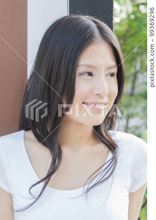 A woman standing in front of a wall A woman standing in front of a wall 99369296