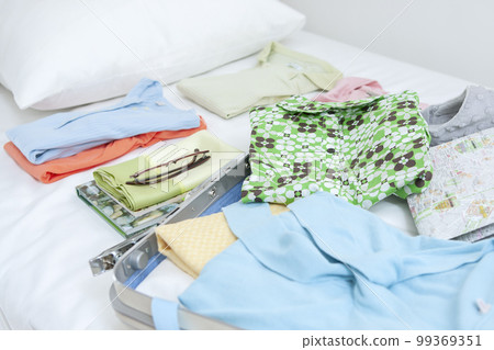 衣服和手提箱在床上 99369351