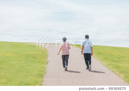 一對老年夫婦在公園散步和有氧運動的後視圖（老年、男性和女性） 99369870