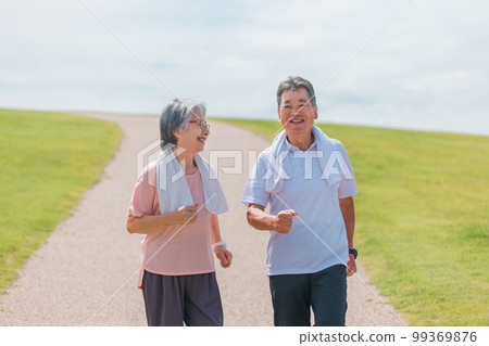 Elderly couple (senior, male and female) walking and aerobic exercise in the park 99369876