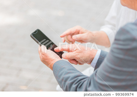 Elderly couple talking while looking at smartphone (senior, male and female) Elderly couple talking while looking at smartphone (senior, male and female) 99369974