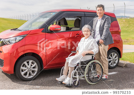 汽車前坐在輪椅上的老年婦女和男子(老人、夫婦、男人和女人) 汽車前坐在輪椅上的老年婦女和男子(老人、夫婦、男人和女人) 99370233