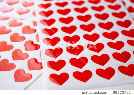 Close up red heart sticker on white paper Close up red heart sticker on white paper 99370792