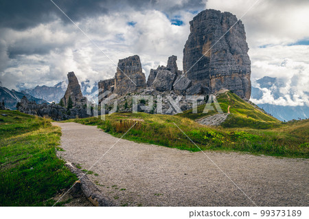 Wide pebbly hiking trail and Cinque Torri rock formations, Dolomites 99373189