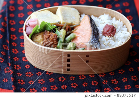 手工製作的日式便當盒,內含烤鮭魚 手工製作的日式便當盒,內含烤鮭魚 99373517