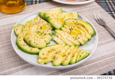 ripe avocado pulp cut into pieces sprinkled with lemon juice on a plate 99374738