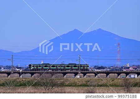 以雄偉的筑波山為背景奔跑的鹿島線E131系列列車 99375188