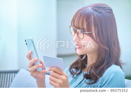 拿著卡片在網上購物的年輕女人 99375352