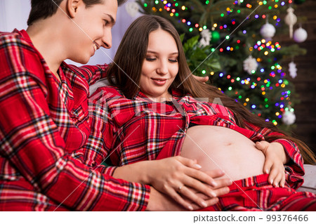 A close-up of the pregnant belly on which the mother-to-be placed her hands. 99376466